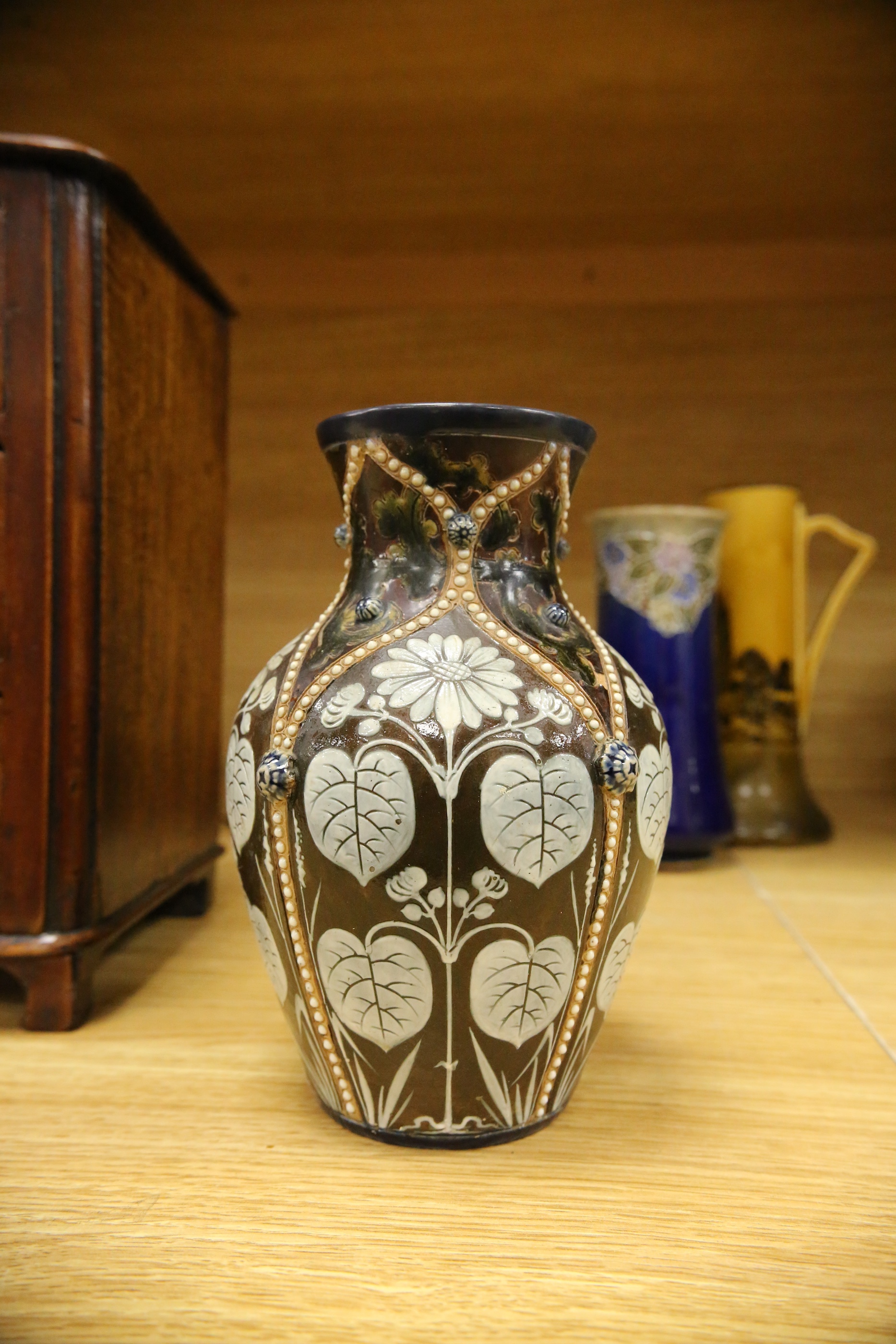 Four Royal Doulton vases and a yellow glazed jug items, tallest vase 34cm high. Condition - some crazing and faults, large vase has damage to lower neck